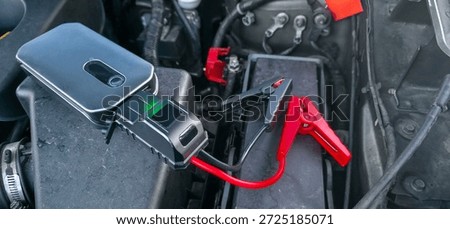 Portable jump starter for a car engine. Assistance for the driver when the car battery is dead.