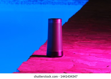 Portable Modern Speaker With Voice Assistant At Night Near The Swimming Pool Neon Light.