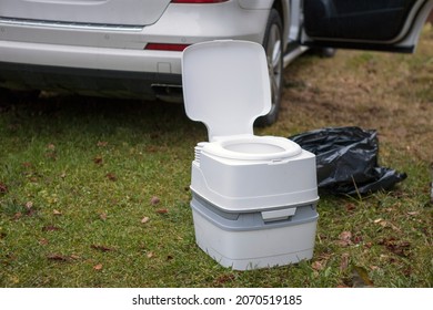 A Portable Potty Next To A Vehicle With Open Door, Outdoor Image