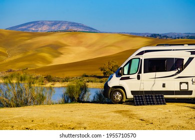 Portable solar panel at camper van camping on nature, lake Embalse del Guadalhorce, Ardales Reservoir, Malaga province in Andalusia, Spain.