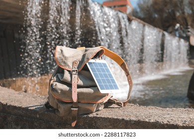 Portable solar panel.Traveler uses green energy to charge gadgets.Eco crisis,eo friendly,sustainable energy,solar panel energy transition,sustainablelifestyle - Shutterstock ID 2288117823