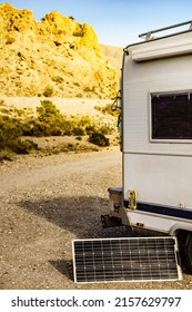 Portable solar photovoltaic panel, charging battery at camper rv camping on mountain nature. Electricity on caravan vacation trip.