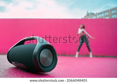 Portable speaker for playing music, product presentation on outdoor dance floor. Advertising of wireless audio device