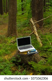 portable technology, solar panel, tablet, laptop and backpack in a birch forest