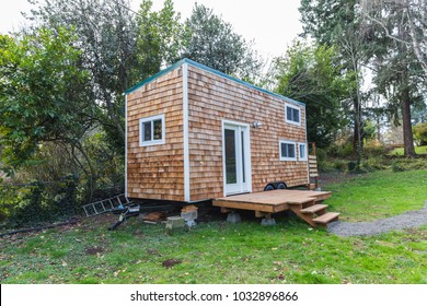 Portable tiny home with wood siding in the back yard of a larger property. Forest Grove, Oregon, USA.