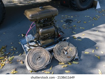 Portable Water Pump Stands On The Pavement.