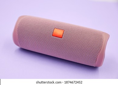 Portable wireless speaker on a colored background.