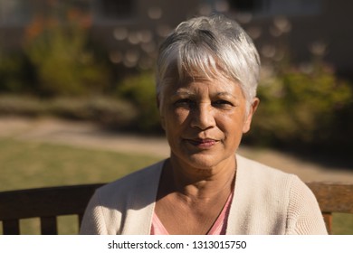 Portait Of Active Serious Senior Woman Sitting On A Bench In The Park On Sunny Day 