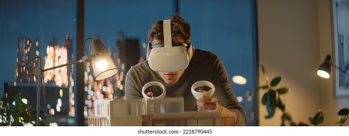 Portait Of Caucasian Male Architect Or Student Using A Virtual Reality VR Headset To Work On A House Project Late At Night, Preparing For Presentation With A Client