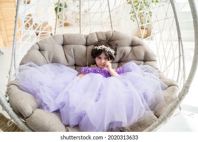 Portait Of Serious Child Girl In Purple  Elegant Dress On Swing