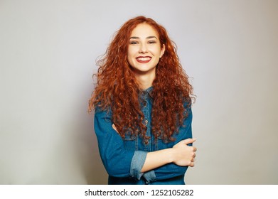 Portait of smiling redhair young woman posing with crossed arms
