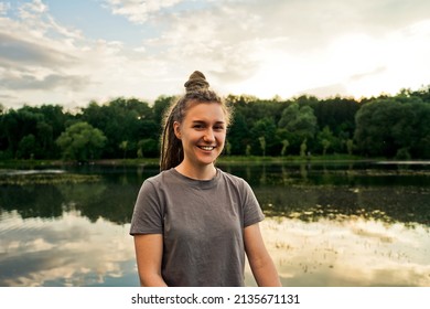 Portait of smiling woman in park, lake background.