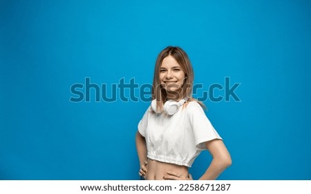 Portaite of happy young beautiful woman with a big white headphones on a neck.