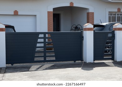 portal modern grey classic metal home gate at entrance of house garden and small gray door pedestrian - Powered by Shutterstock