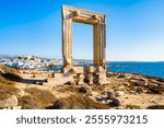 Portara monument also known as Temple of Apollo overlooking port and town on sea coast, Naxos island, Cyclades, Greece