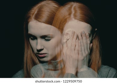 Porter of beautiful redhead girl with psychotic disorders covering her face, hiding from her hallucinations