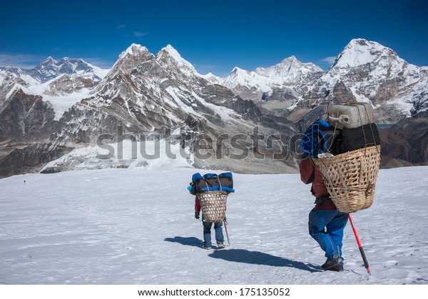 Porter\
carrying heavy loads in Himalayas of\
Nepal