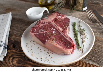 Porterhouse Steak Dry Aged And Raw With Seasoning And Herbs