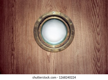 Porthole Windows With Brass Frame On The Old Nautical Vessel Or On The Yacht. Ship's Porthole With Circle Bronze Border At Wooden Background For Your Retro Poster Of Marine Cruise Or Sea Voyage.