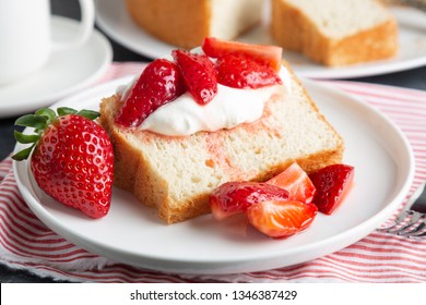 Portion of angel food cake served with whipped cream and strawberries 