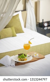A portion of avocado salad with lettuce and freshly squeezed orange juice served in a hotel room, room service, healthy start of the day - Shutterstock ID 1313244797