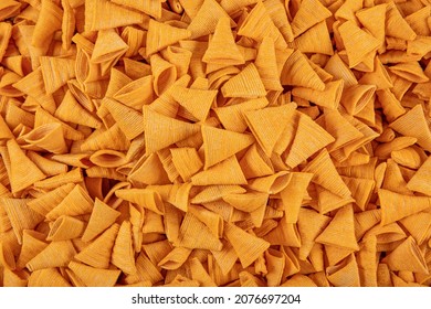 Portion Of Cone Shaped Snack Tornado Shaped Crackers. Yellow Spicy Potato Cone Chips Texture Or Background Of Corn Cone. 