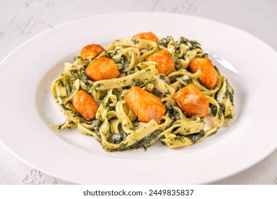 Portion of creamy spinach pasta with salmon - Powered by Shutterstock