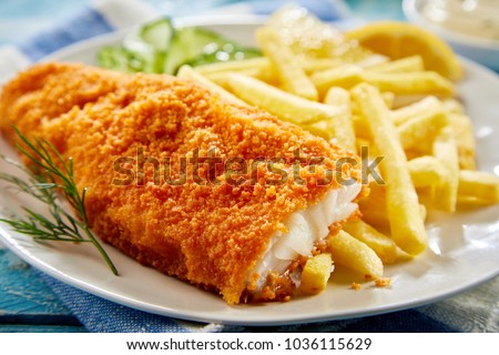 Portion of crispy breaded fish fillet with french fries served on plate