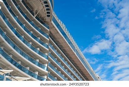 A portion of cruise ship with multiple decks and balconies looming overhead  yields an abstract study in color and line