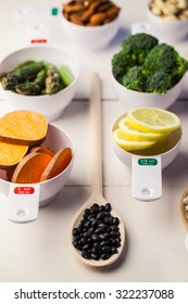 Portion cups of healthy ingredients on wooden table Foto Stok