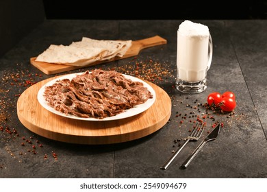 Portion Doner kebab meat served in plate with Pita Bread, Glass of Ayran, knife, fork and tomato isolated on wooden background side view of arabic and turkish fast food - Powered by Shutterstock