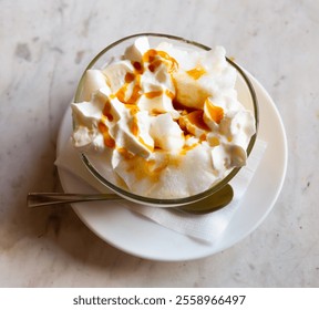 Portion of floating island, French dessert, served in glass bowl with spoon. - Powered by Shutterstock