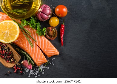 Portion Of Fresh Salmon With Spices,herbs And Vegetables On Black Slate Background