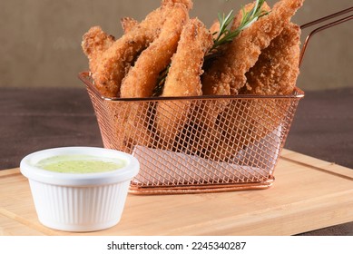 portion of fried fish, fried chicken strips inside metal basket tasty snack - Shutterstock ID 2245340287