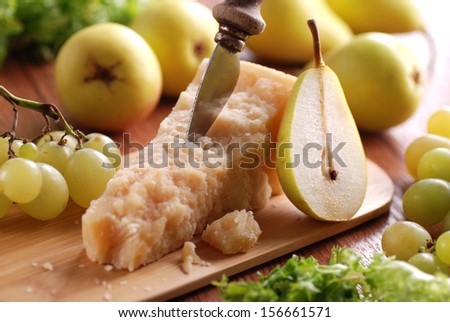 portion of parmesan cheese with pears around