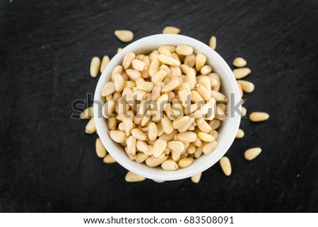 Portion of Pine Nuts on a rustic slate slab (selective focus; close-up shot)
