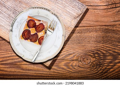 Portion Of Plum Cake On A Porcelain Plate With A Fork. View From Above.