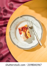 Portion Of Plum Cake On A Porcelain Plate With A Fork. View From Above.