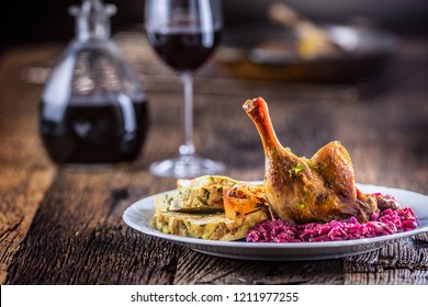 Portion Of Roast Duck Leg Red Cabbage Homemade Dumplings On Plate And Red Wine On The Background.