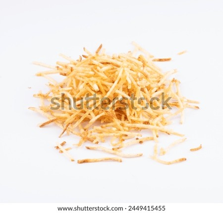 portion of shoestring potatoes scattered in white background top view