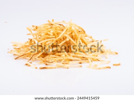 portion of shoestring potatoes scattered in white background from front