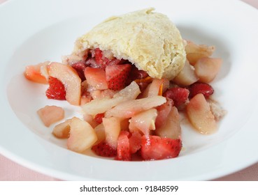 A Portion Of Steamed Pear And Strawberry Pudding In A Suet Pastry Crust Served In A White Bowl