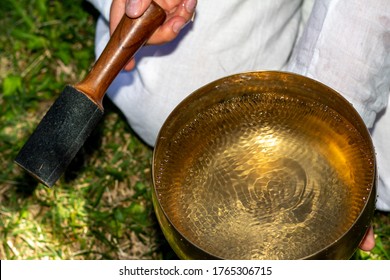 Portion Of A Tibetan Bell With Water Inside That Ripples With The Sound Waves Emitted After Percussion With The Special Wooden Instrument