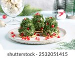 Portioned tuna pate on cracker decorated with dill and pomegranate seeds. Christmas appetizer in shape of Christmas tree. 