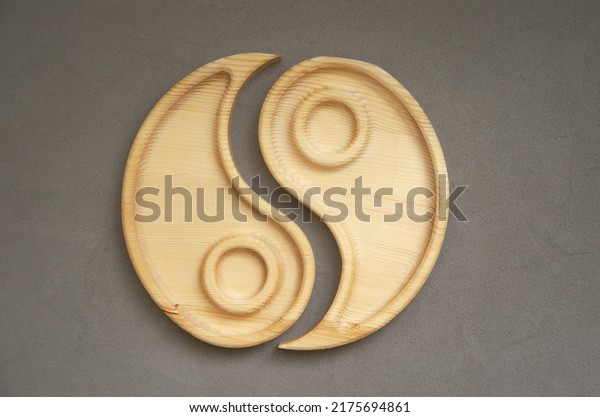 Portioned wooden yin yang dish on\
a gray background. Empty plate or tray, top view. combination\
plate