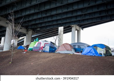 PORTLAND, OR - FEBRUARY 27, 2016: Homeless camps with tents and tarp shelter under a bridge in downtown Portland Oregon.