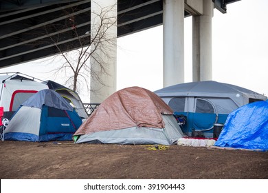 PORTLAND, OR - FEBRUARY 27, 2016: Homeless camps with tents and tarp shelter under a bridge in downtown Portland Oregon.