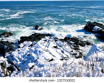 Portland Head Light Off Shore Waves Beating On The Rocks After Snow In New England Winter In Cape Elizabeth, Maine, United States.