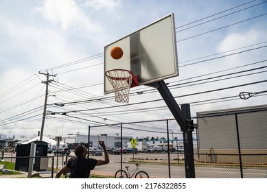 Portland, Maine -April 4, 2022: Cute Teenager Iplaying Basketball. Young Boy With Red Ball Shooting On The City Court. Hobby For Kids, Active Lifestyle. Portland Maine