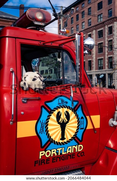 Portland, Maine -\
U.S.A. - 10-28-2021: A stuffed dog hangs out of the window of a old\
Portland Fire Truck in\
Maine.